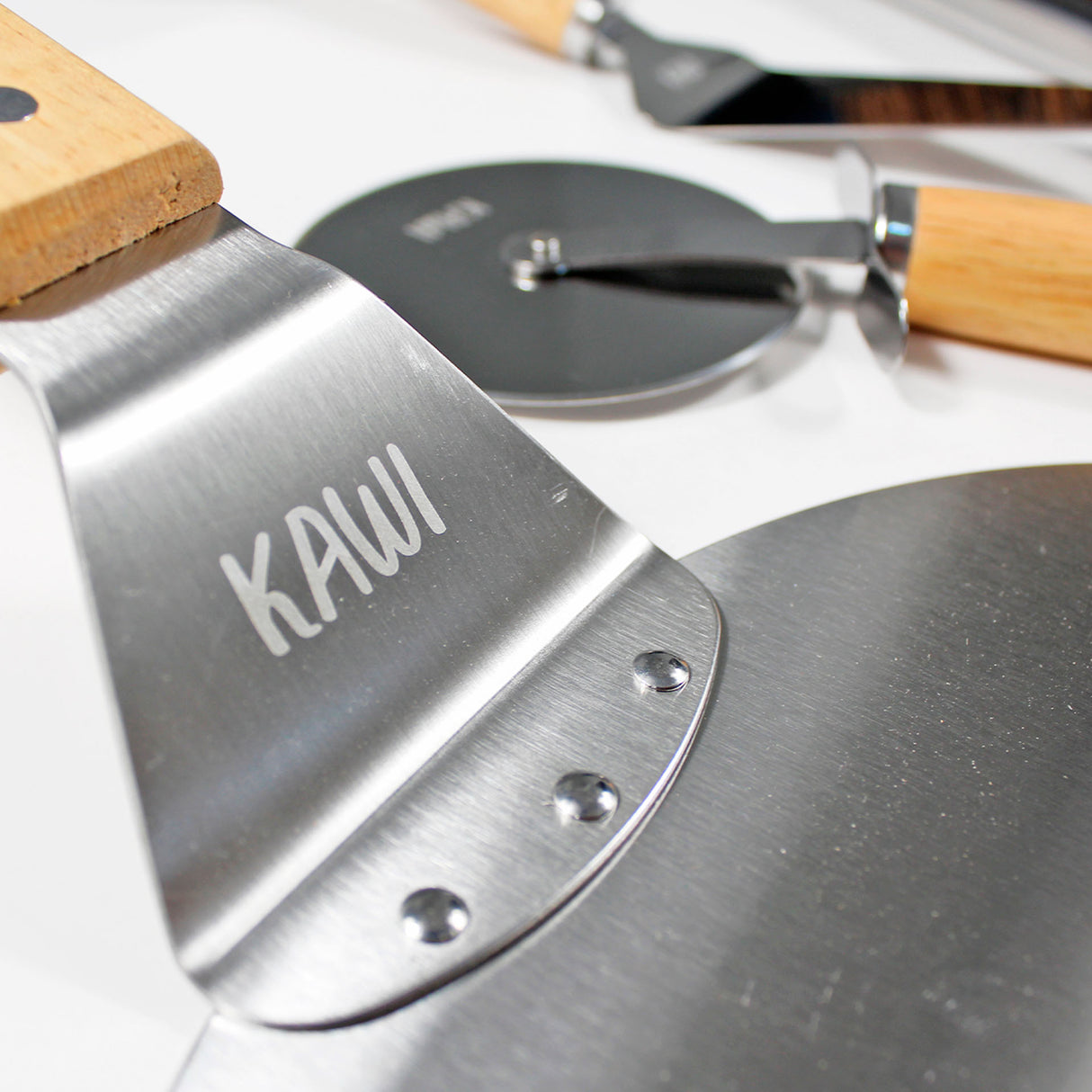 Set para pizza Kawi Pizzaiolo de 4 piezas: cortador, pala, cepillo y espátula. Acero inoxidable y madera. ¡Prepara y sirve pizza como un profesional! Compra online, envío a Chile.