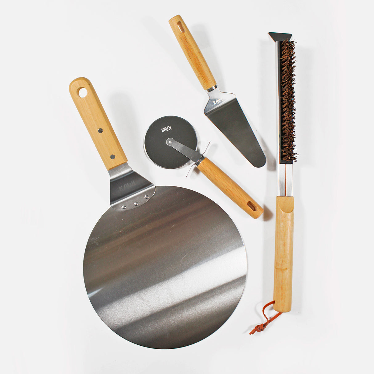 Set para pizza Kawi Pizzaiolo de 4 piezas: cortador, pala, cepillo y espátula. Acero inoxidable y madera. ¡Prepara y sirve pizza como un profesional! Compra online, envío a Chile.
