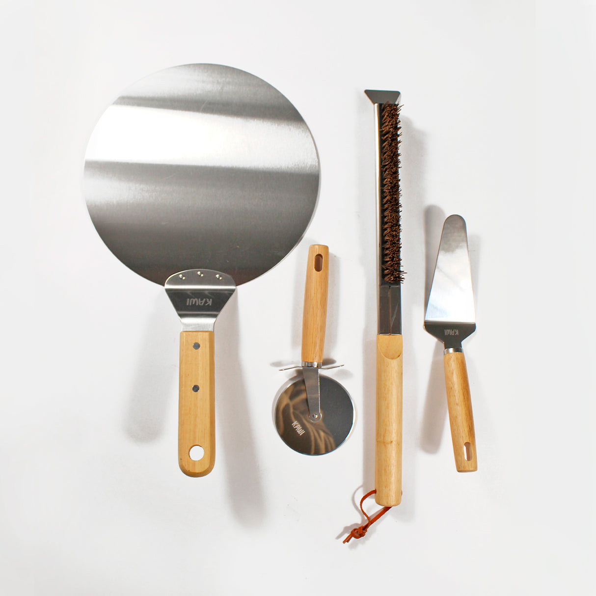 Set para pizza Kawi Pizzaiolo de 4 piezas: cortador, pala, cepillo y espátula. Acero inoxidable y madera. ¡Prepara y sirve pizza como un profesional! Compra online, envío a Chile.